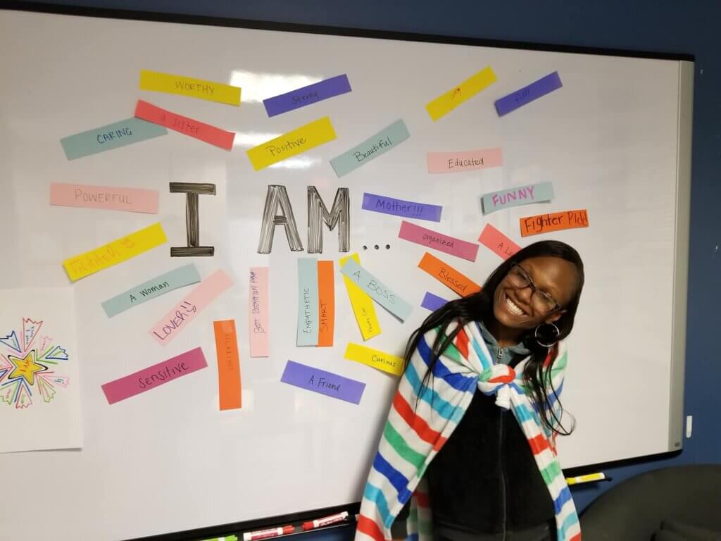 Young woman standing in front of affirmations