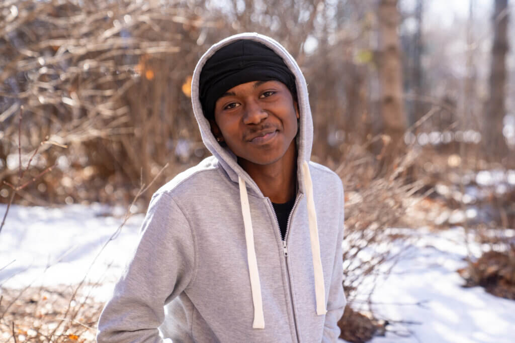 Youth outside in hoodie smiling