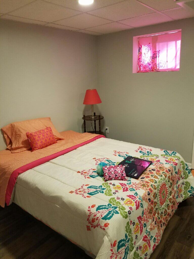 Bedroom with orange bedspread and pink curtains