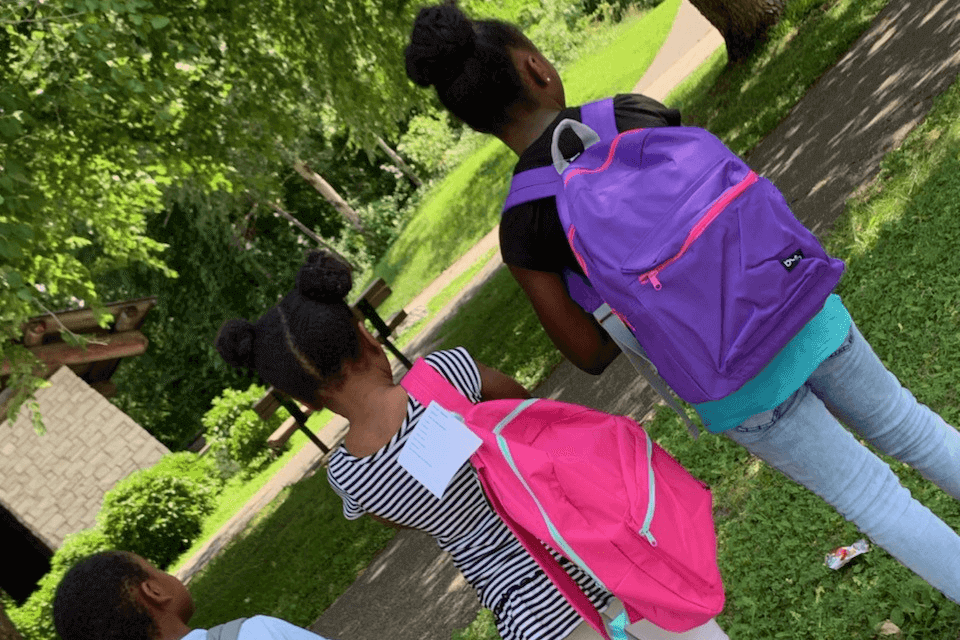 Three youth wearing backpacks