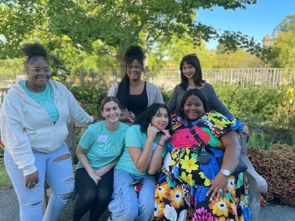 Group photo of youth sitting on a bench in a park